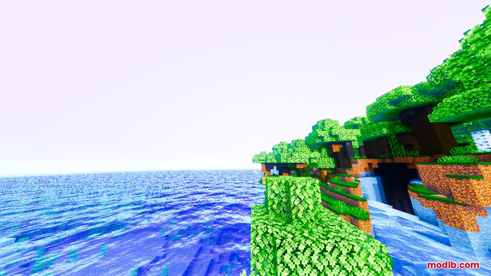 Vibrant green trees grow on a cliff beside a glassy blue ocean surface