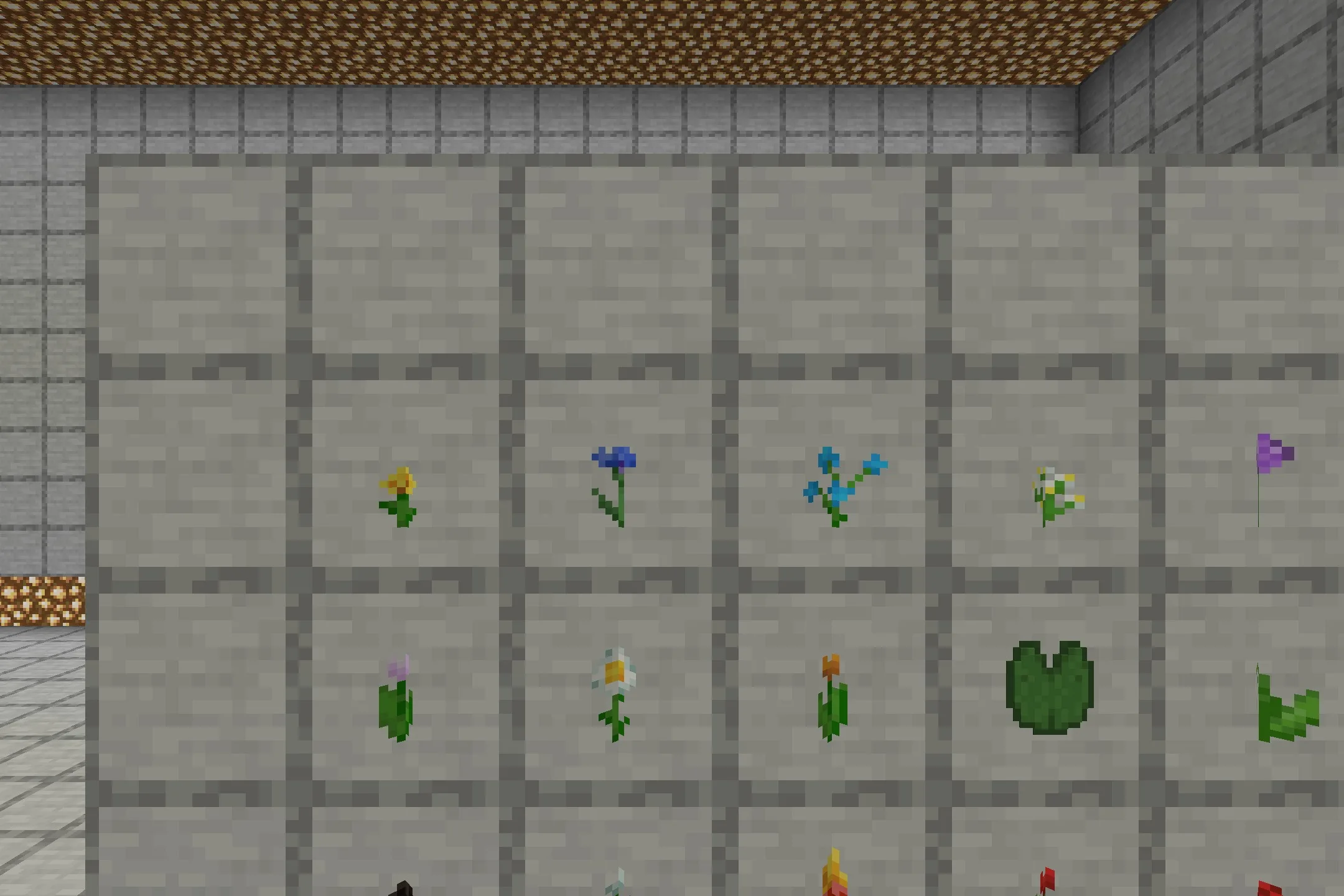 Various Minecraft flowers and a lily pad displayed in item frames on stone