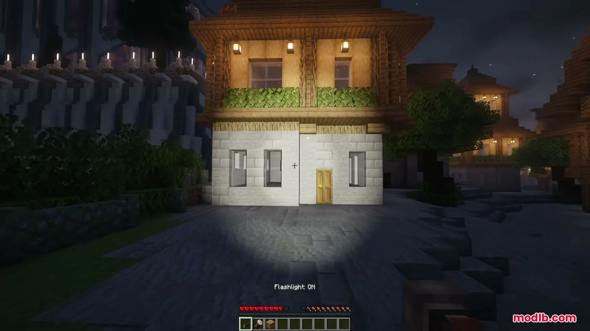 Flashier Flashlights Mod Screenshot 4 The flashlight beam illuminates the front of a house with realistic shadows
