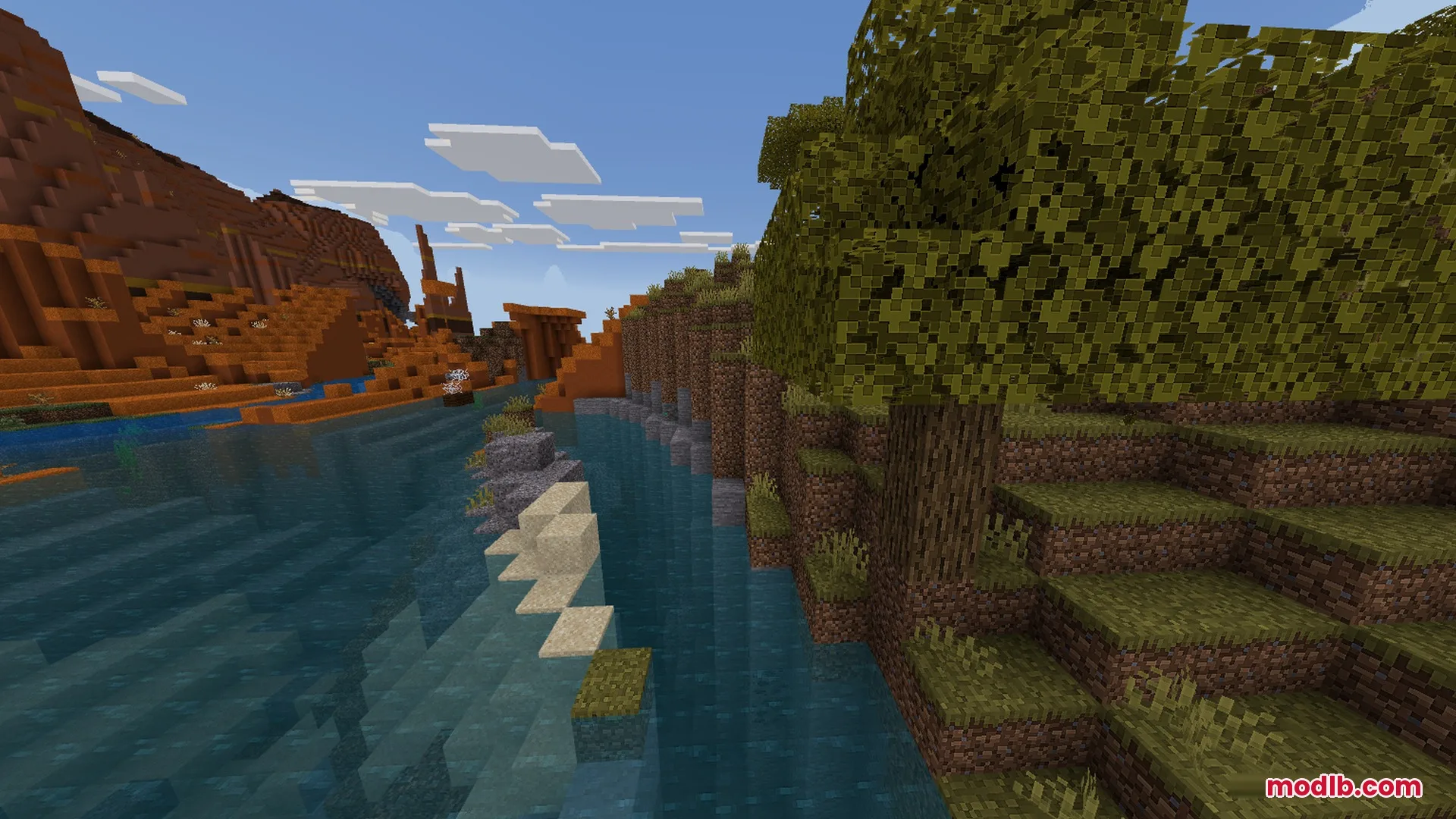 A scenic river flows between a red mesa and a lush forest biome