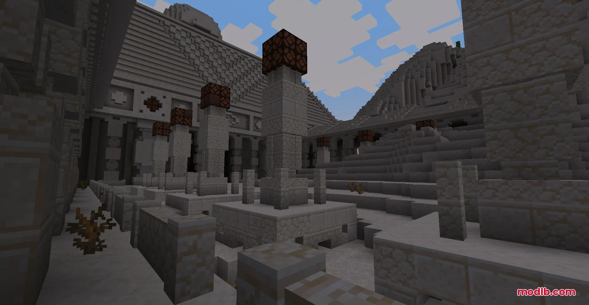 Exterior view of a large sandstone monument with pillars and redstone lamps