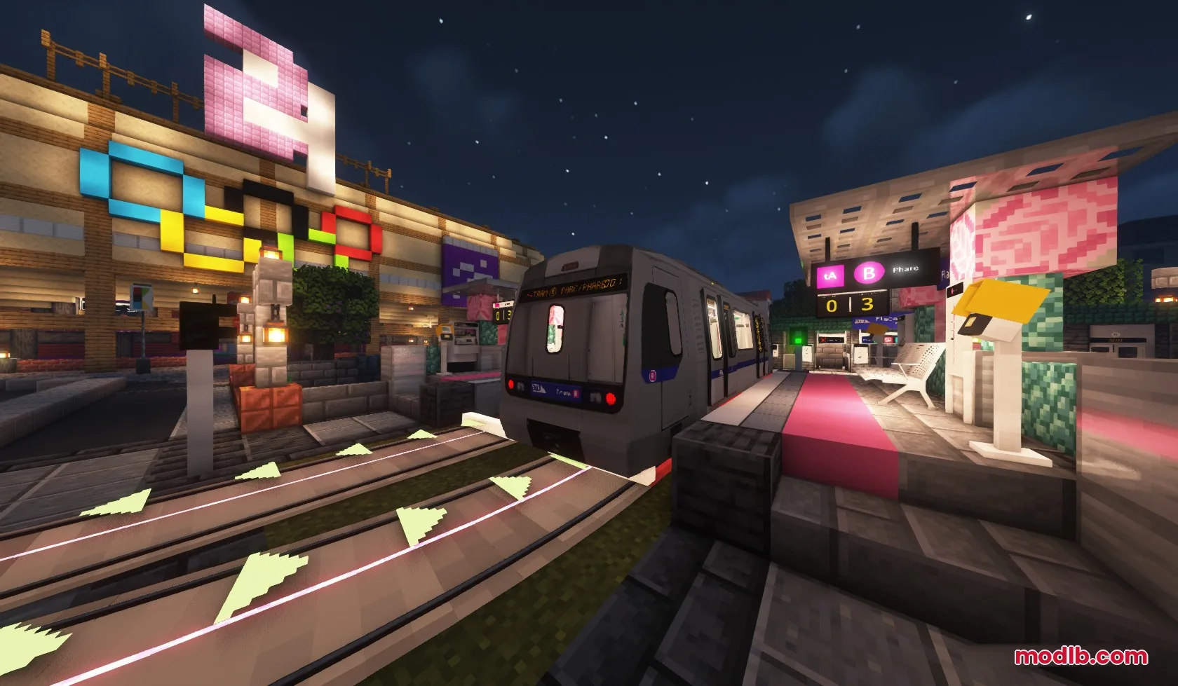 A modern train arrives at a brightly lit outdoor station at night