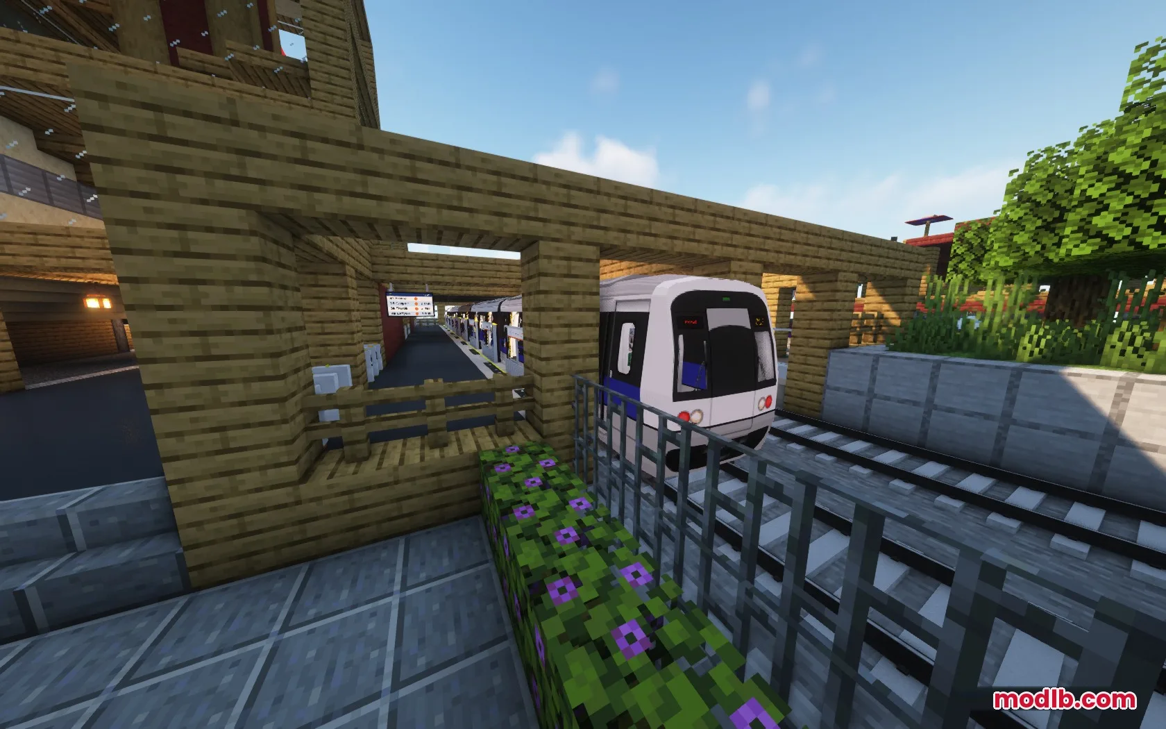 A white and blue STB Metro train pulls into a wooden station platform