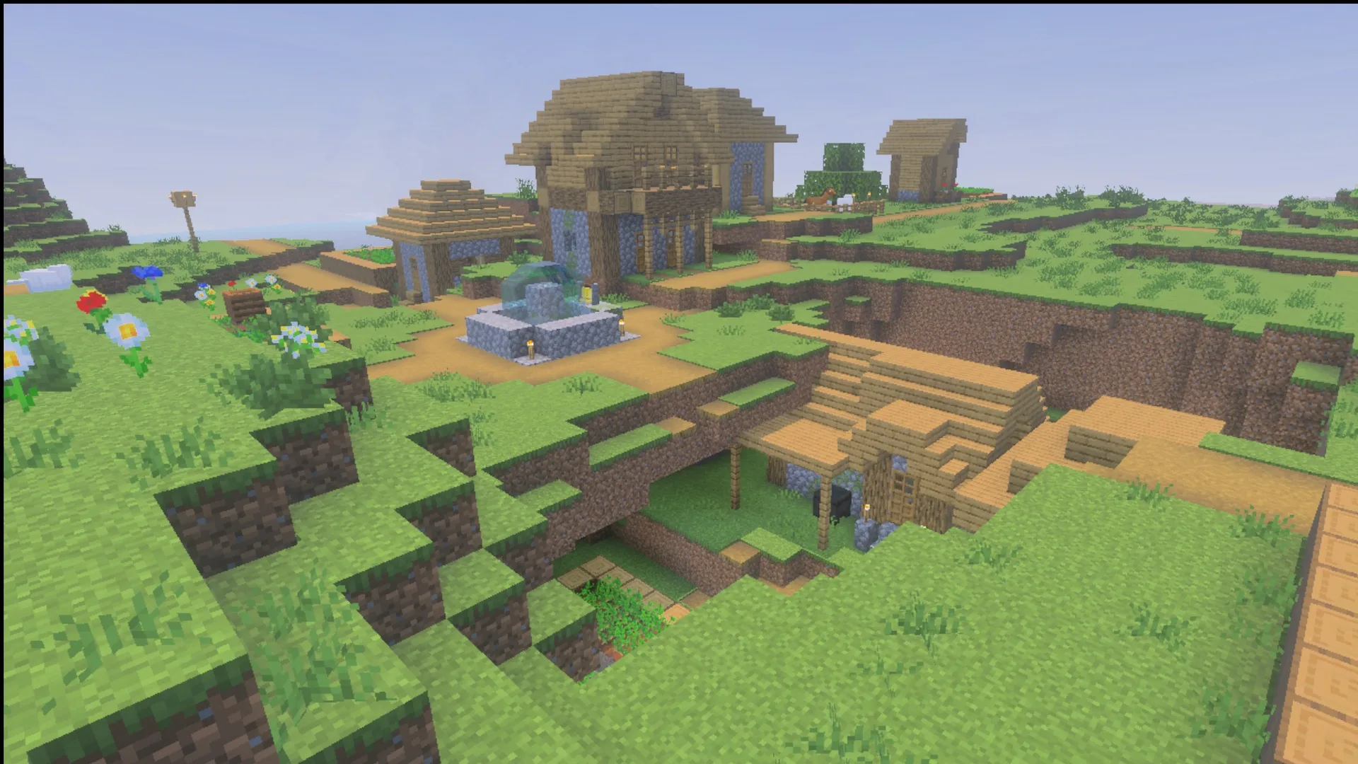 Ultimate Survival Texture Pack Screenshot 2 Village buildings and a fountain in daylight showing the Ultimate Survival block textures