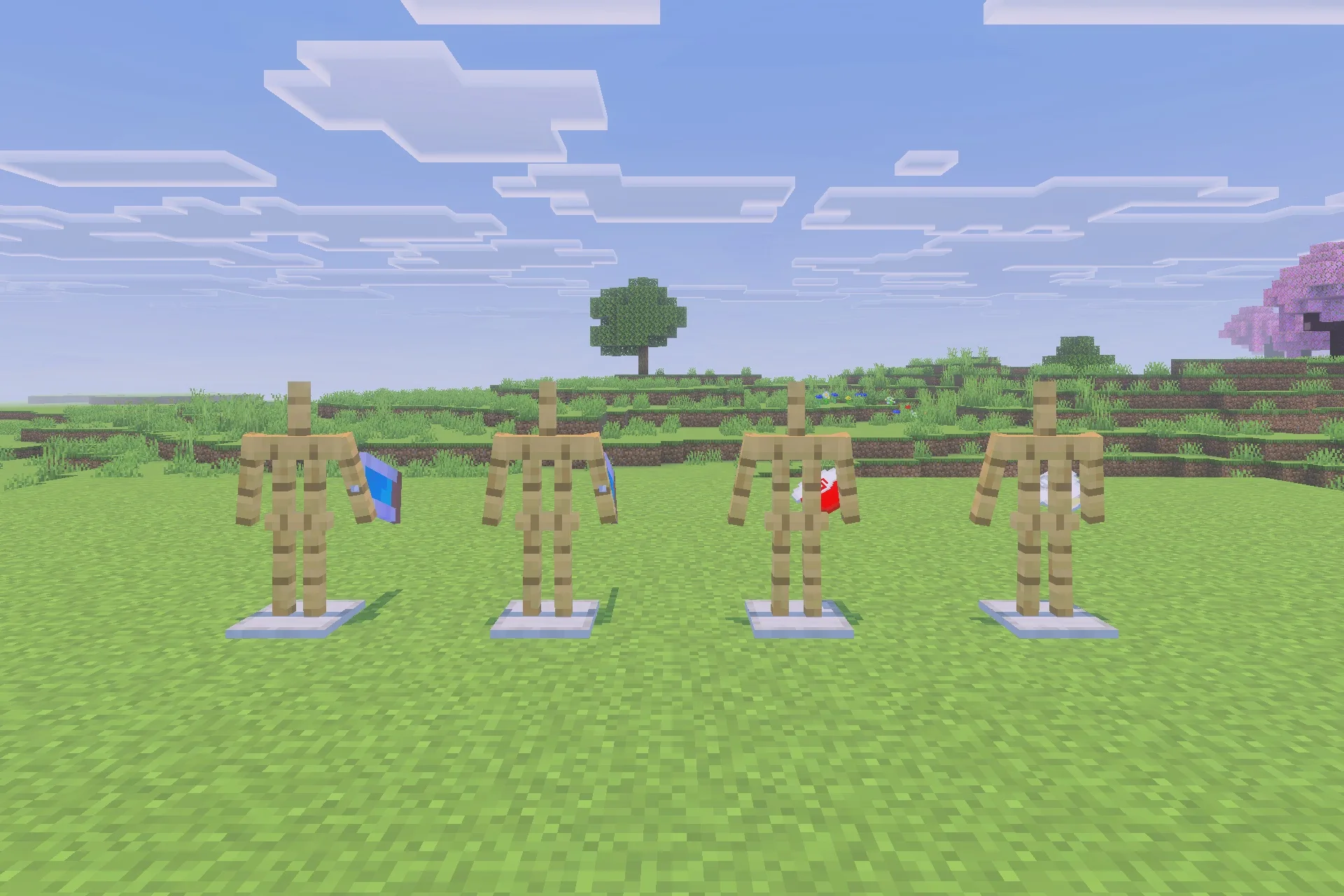Four armor stands displaying various character suits and capes on the grass
