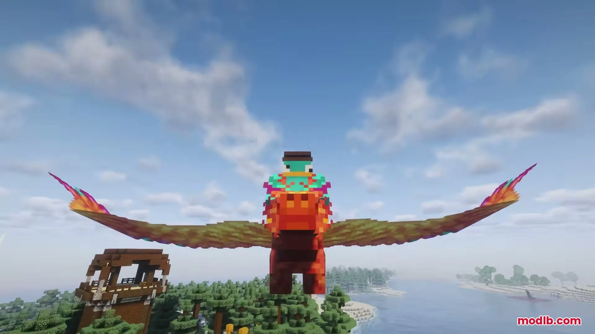 Wings of Fire by RipleysMods Mod Screenshot 1 A player riding a colorful phoenix mount above a pillager outpost in Minecraft
