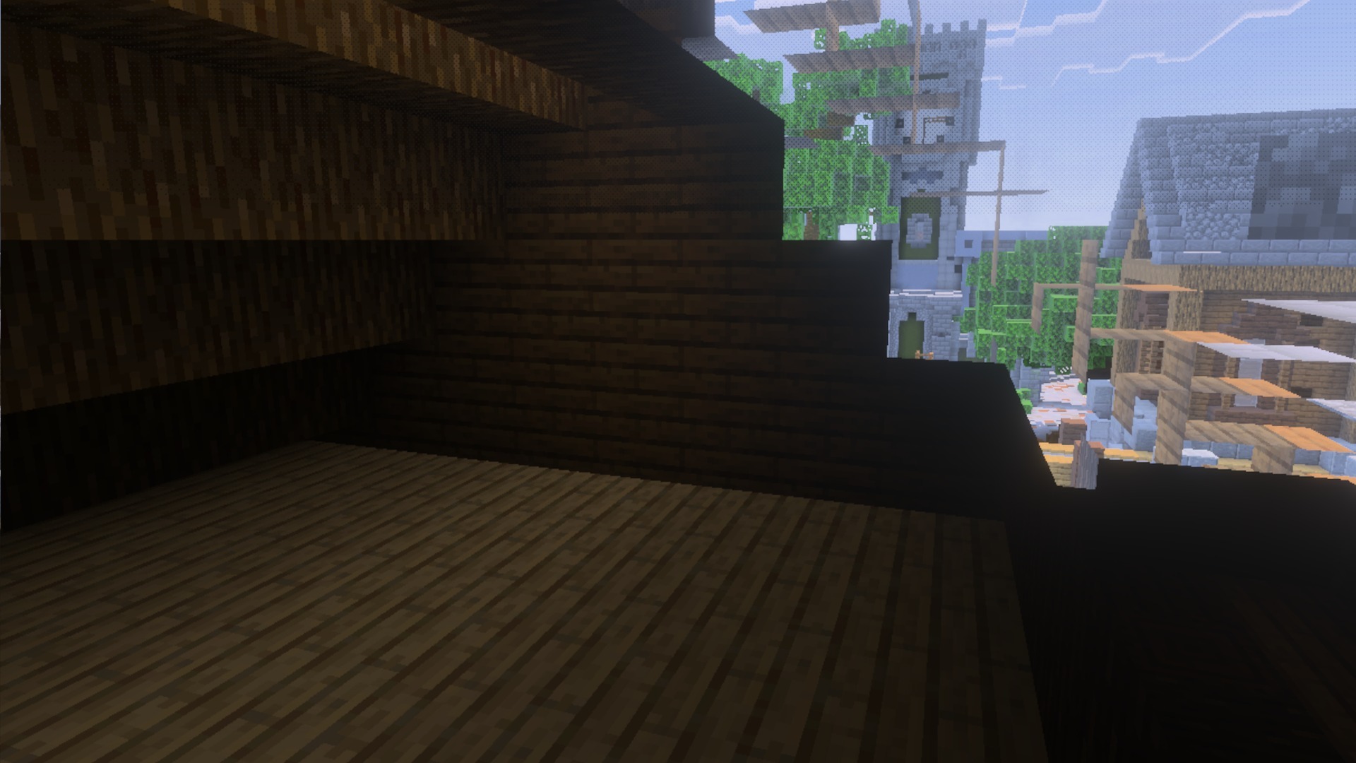 Looking out from a dark wooden room at a stone tower and buildings
