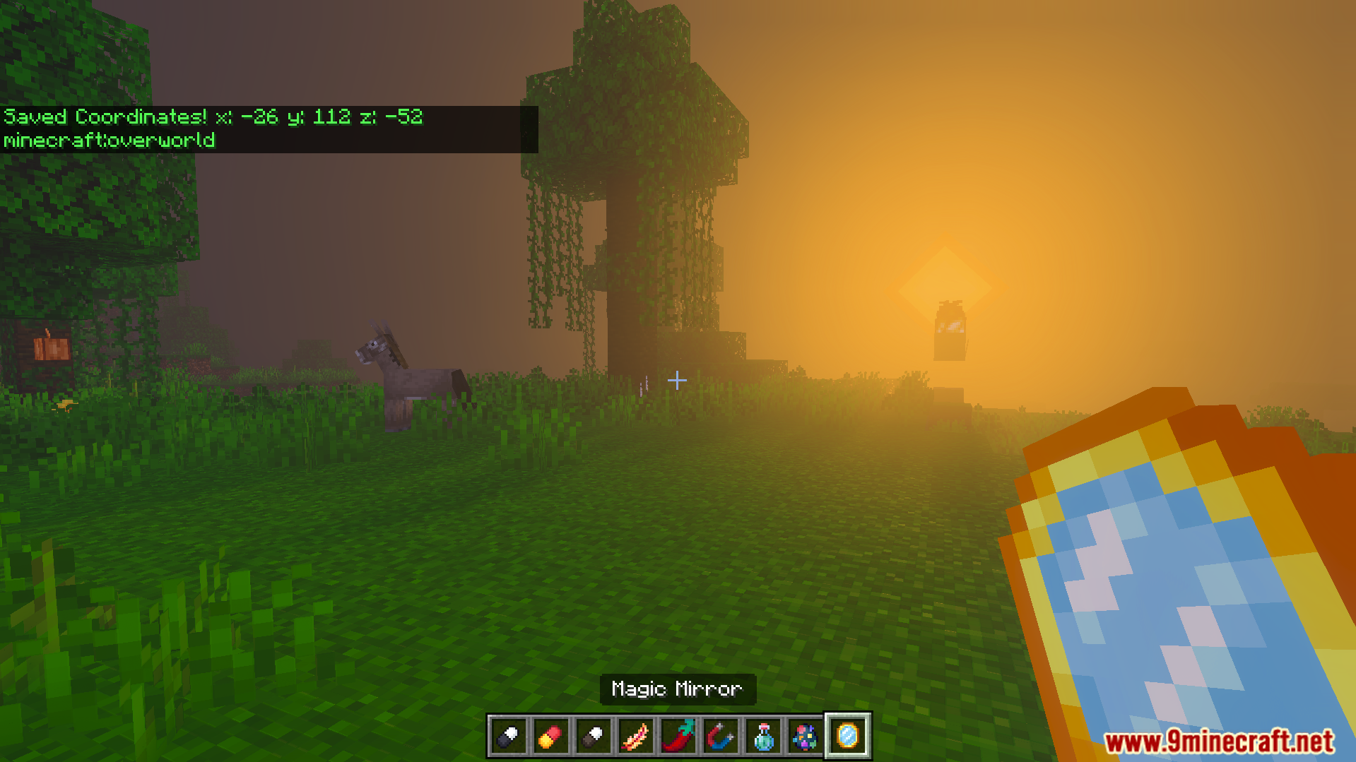 Player holding Magic Mirror item in grassy area at sunset