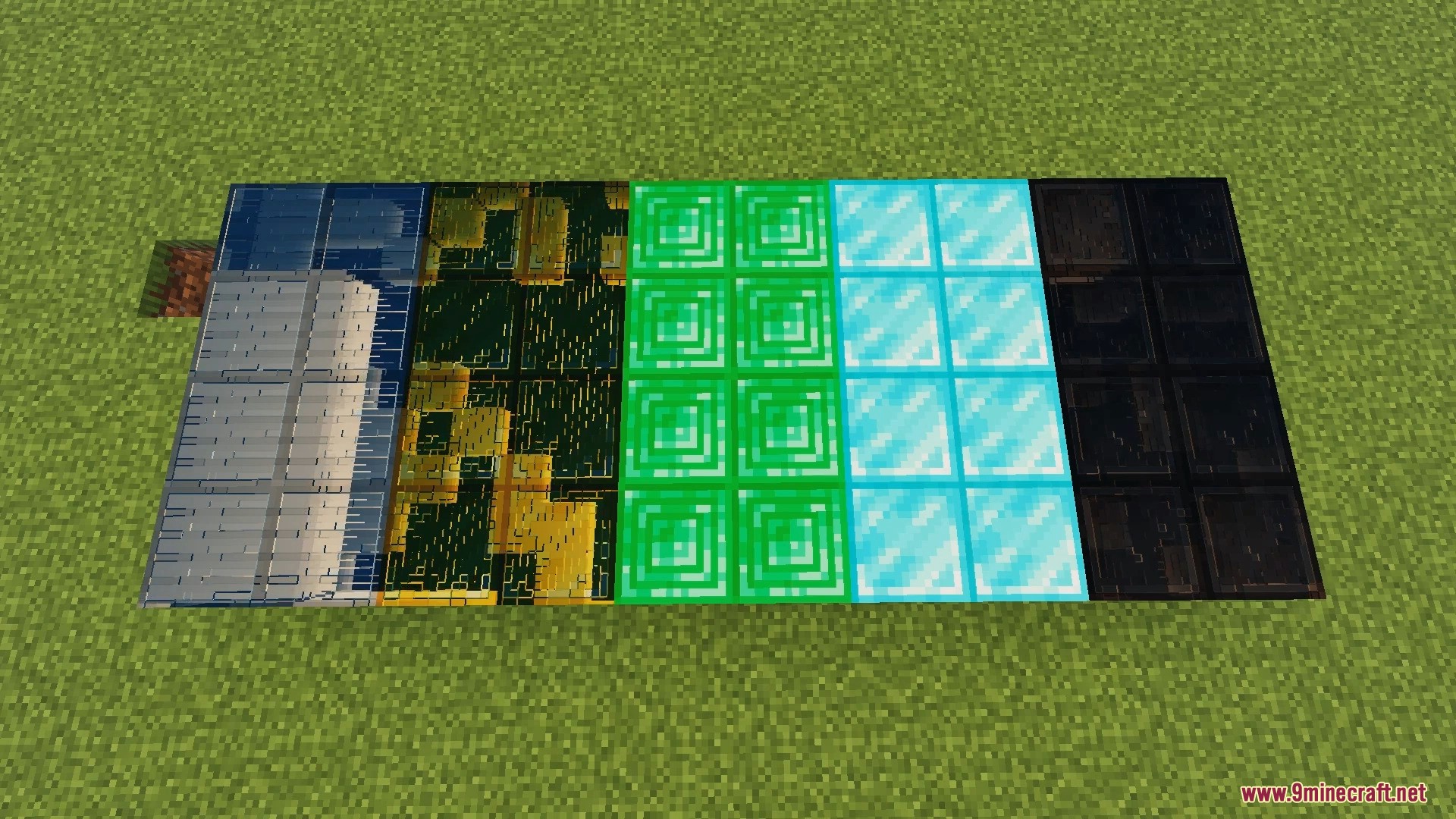 Reflective glass gold emerald and diamond blocks placed on grass