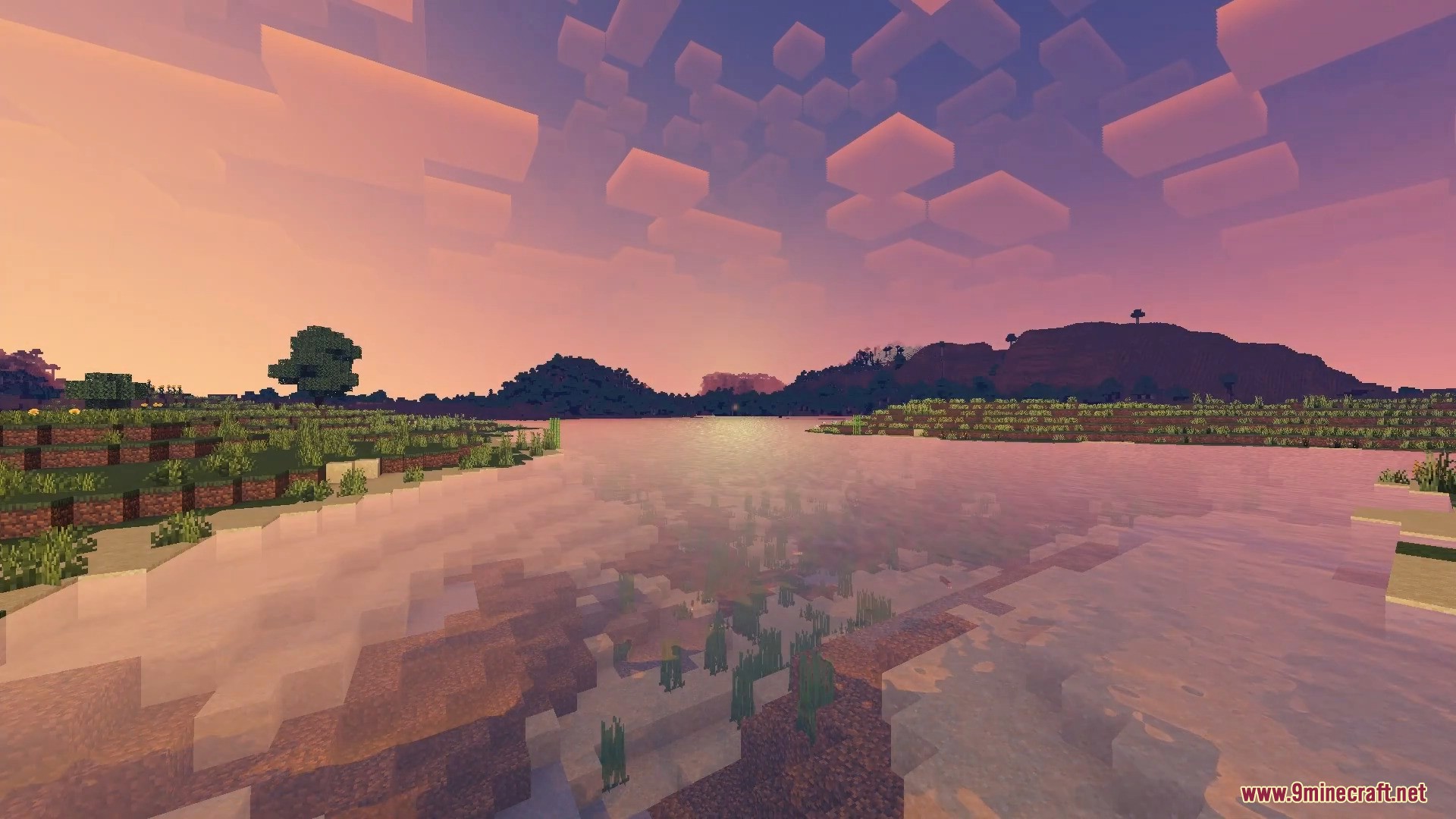Scenic Minecraft sunset showing calm water reflections and blocky clouds over distant hills