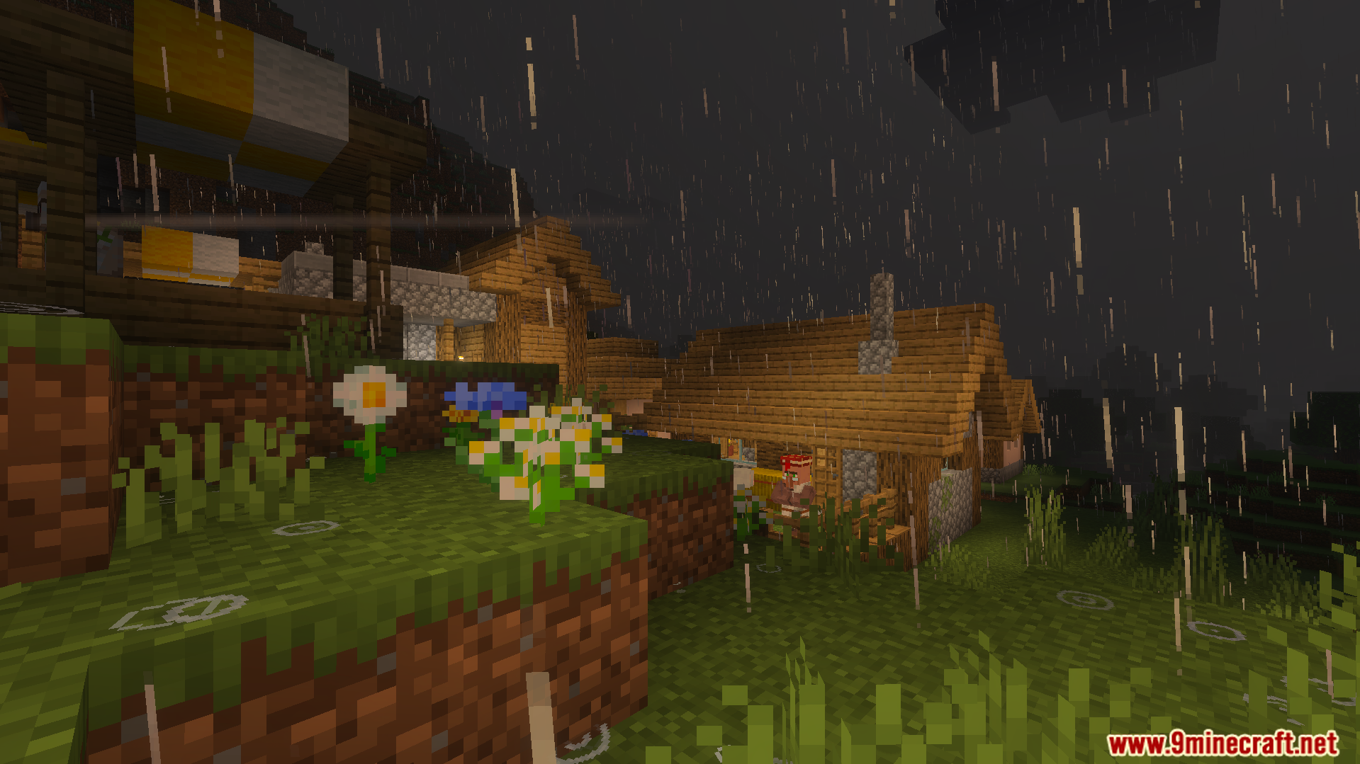 Wind driven rain falling over a village with wooden houses and flowers