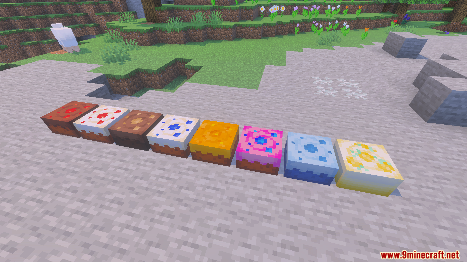 Several unique colorful cake blocks placed in a line on the ground