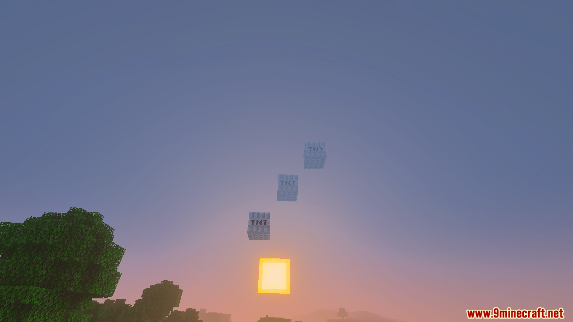 Three fake explosive blocks floating in the sky at sunset