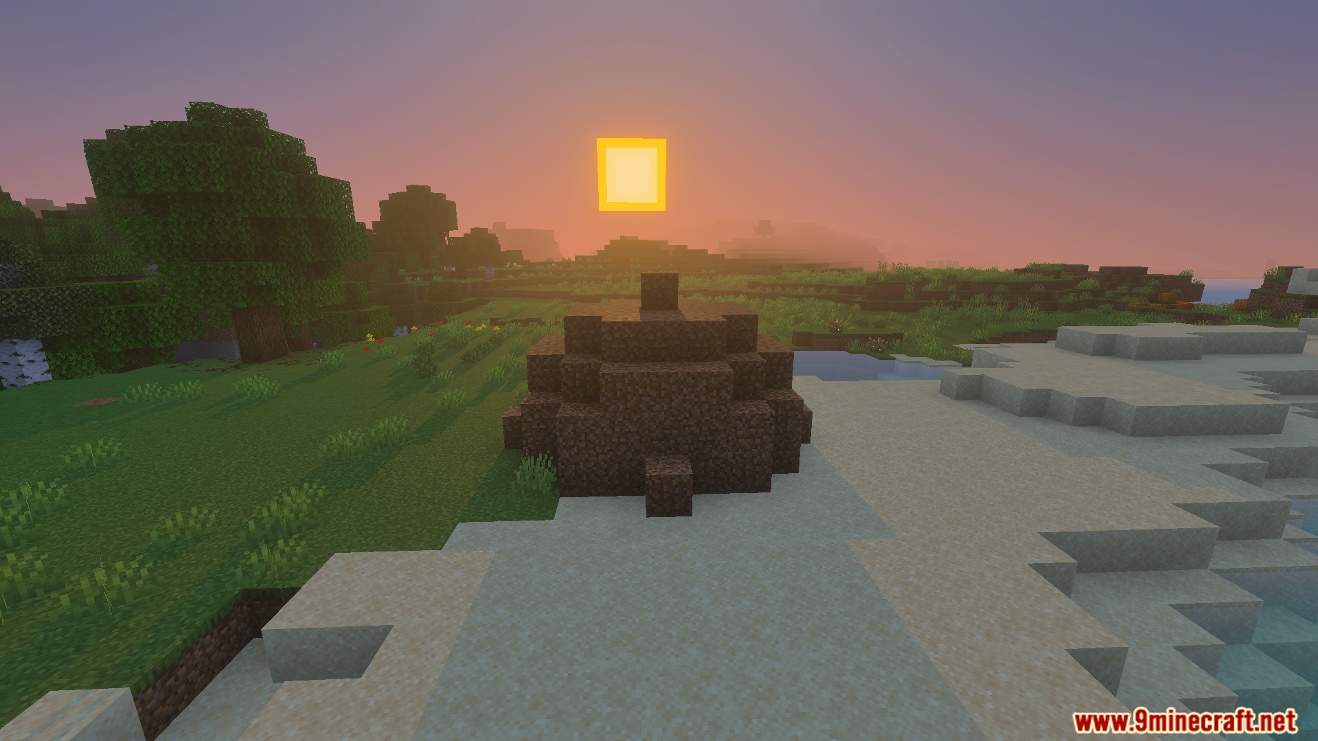 A large pile of dirt blocks sitting on a sandy beach at sunset