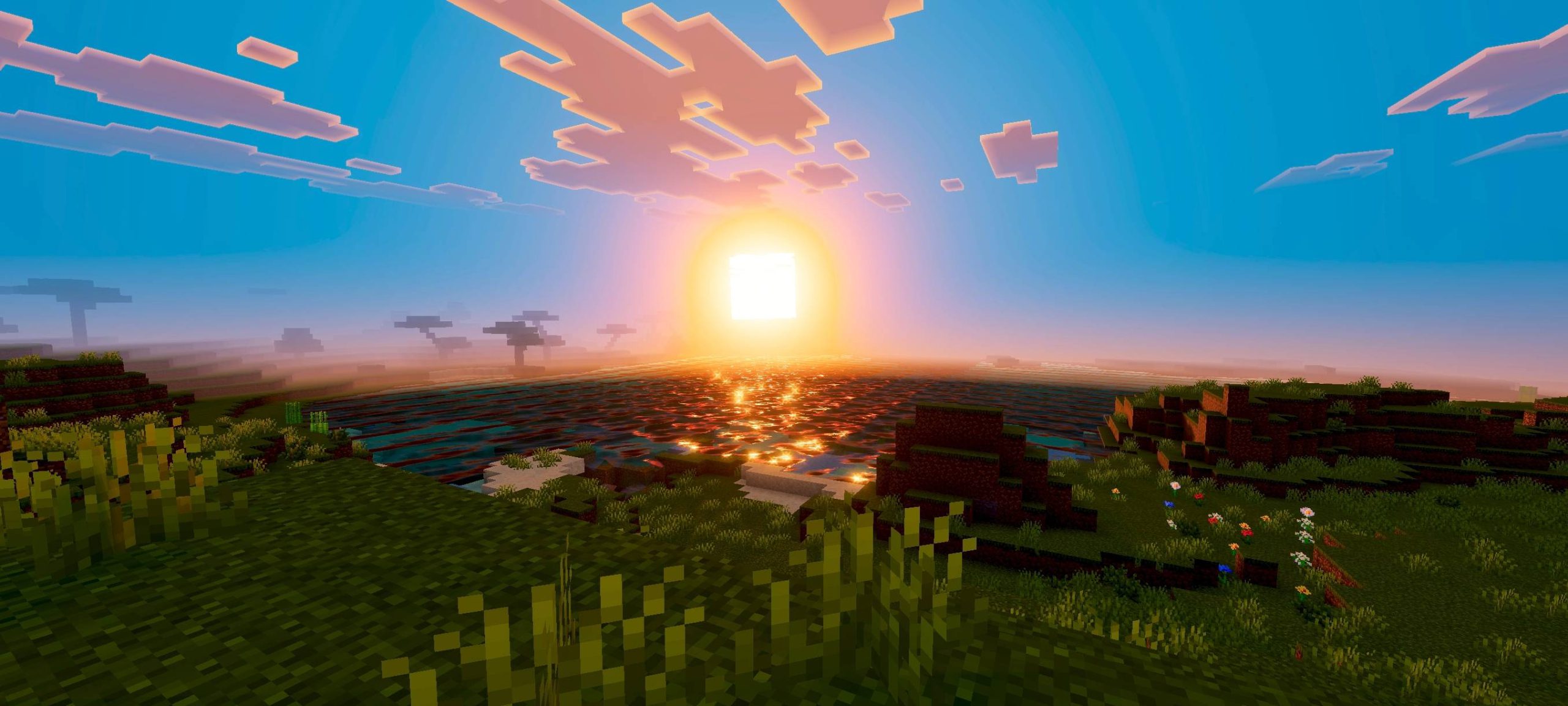 Warm and saturated sunset lighting over a grassy landscape with square clouds