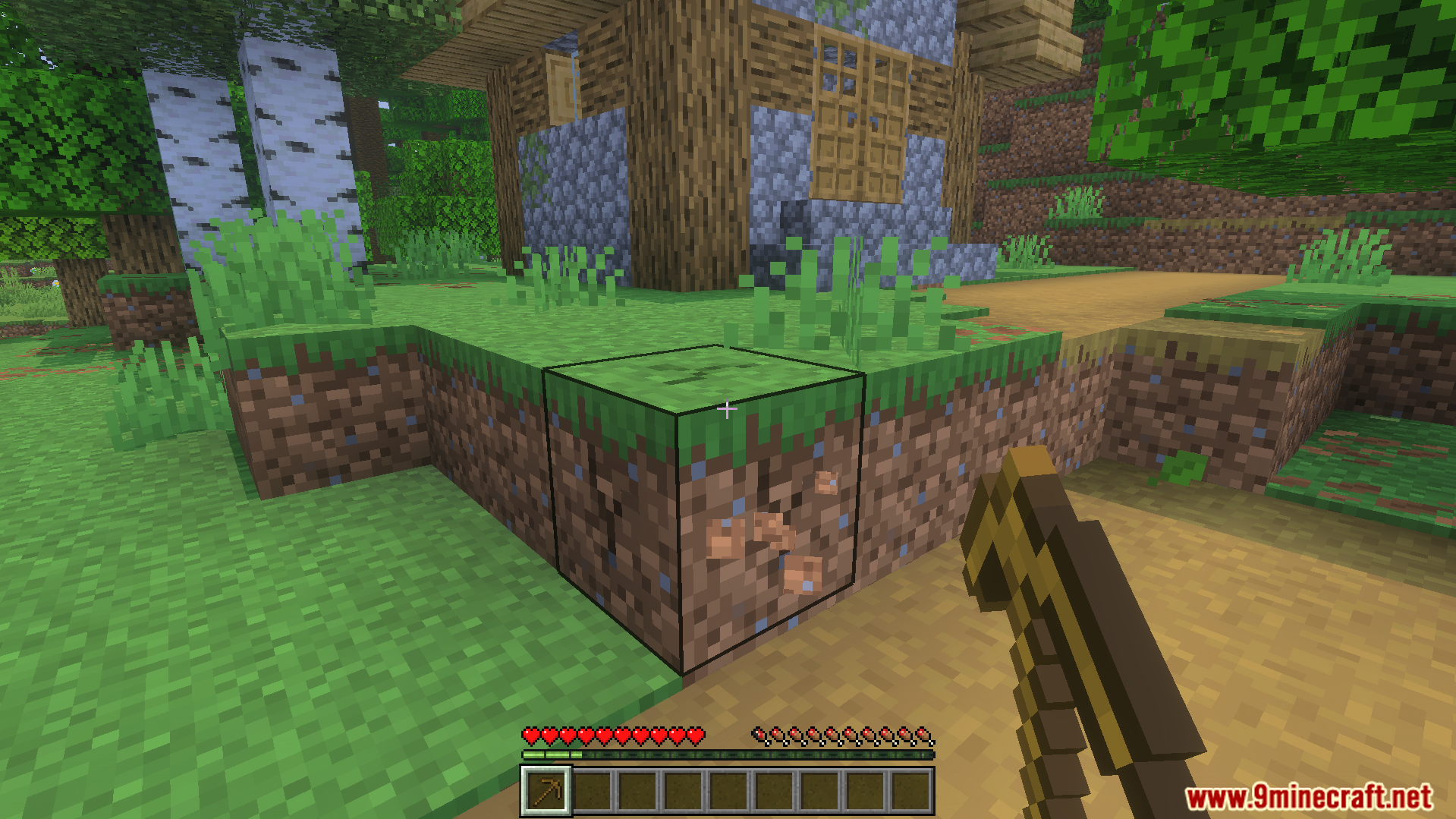 Random Enchantment Addon Screenshot 3 Player holding a wooden pickaxe while standing in front of a village house