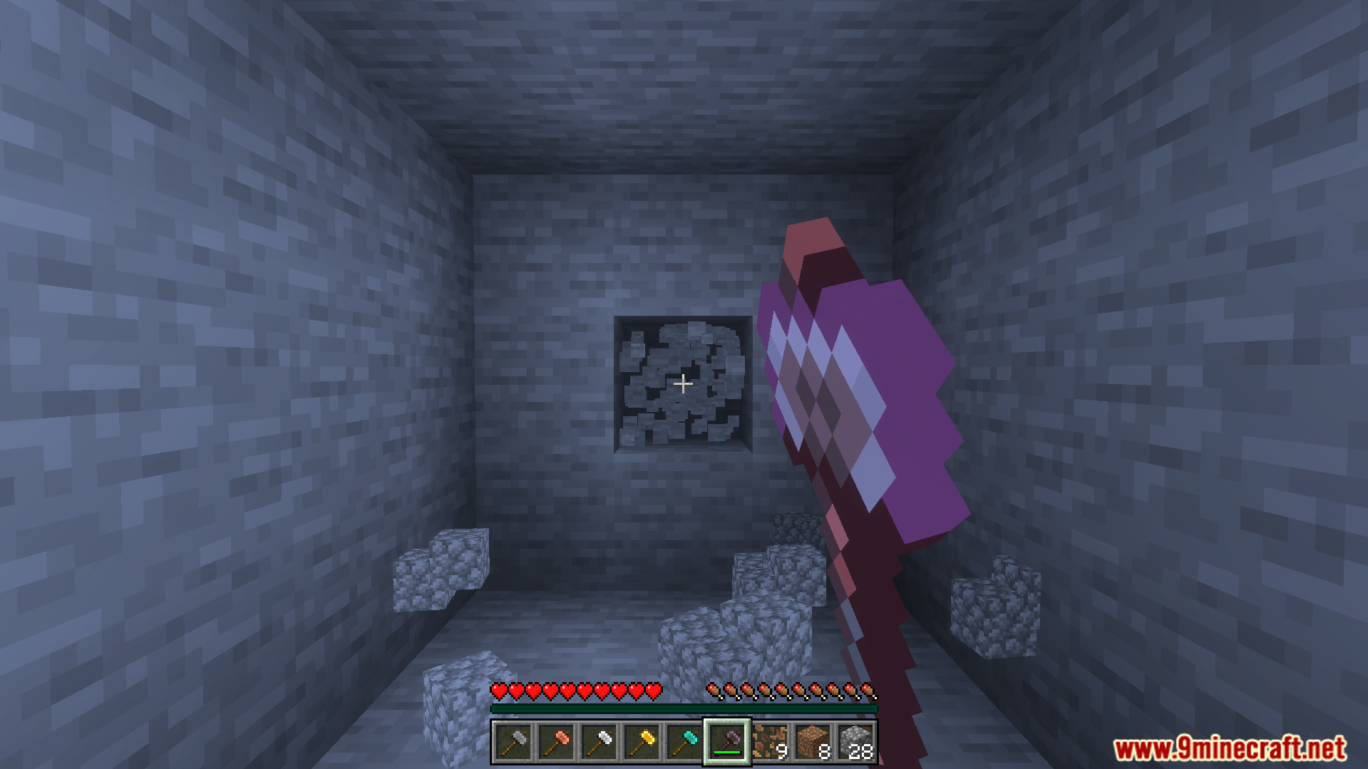Player holding a new hammer tool facing a stone wall in cave