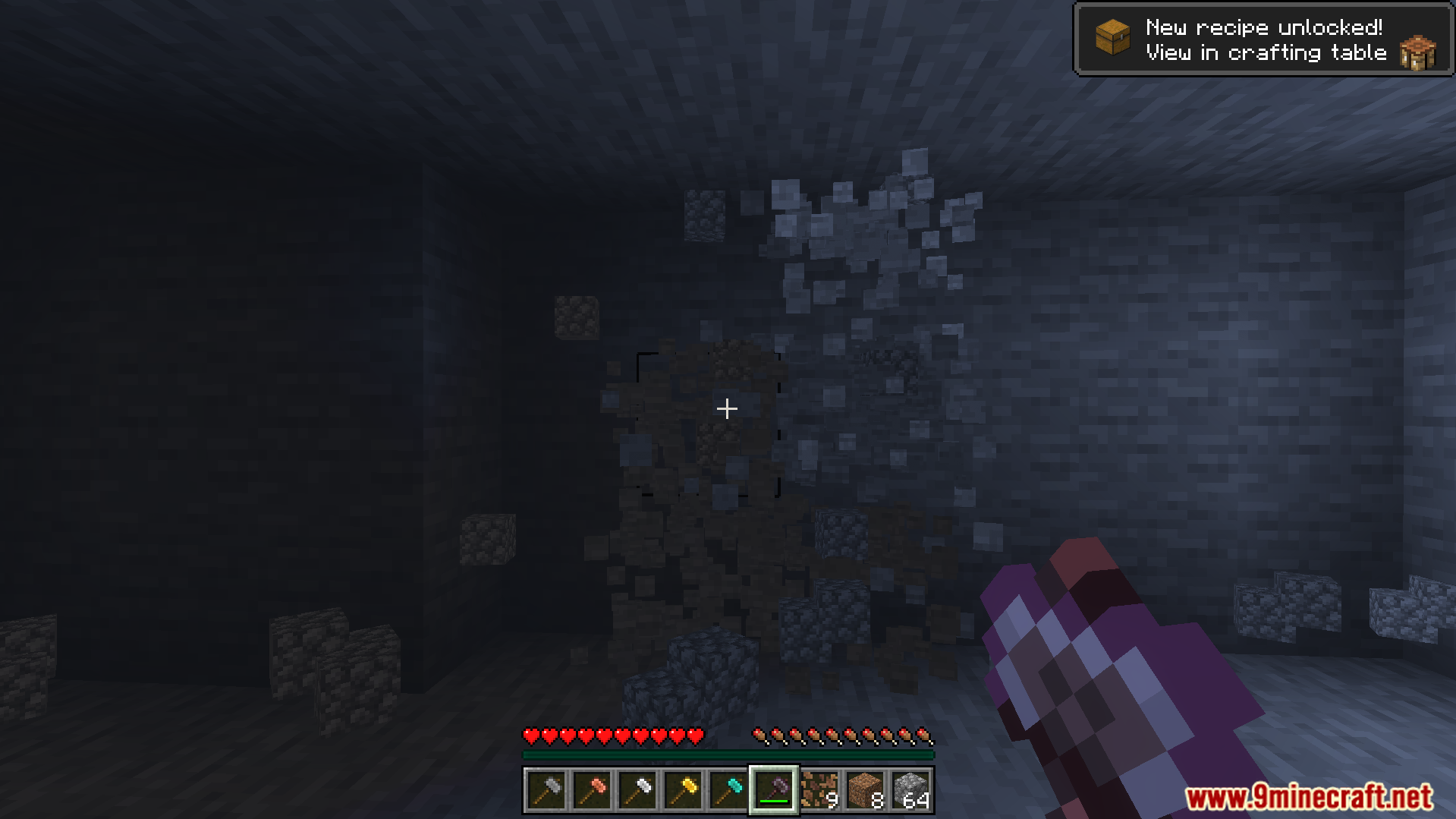 Mining a three by three area of stone blocks in a dark cave