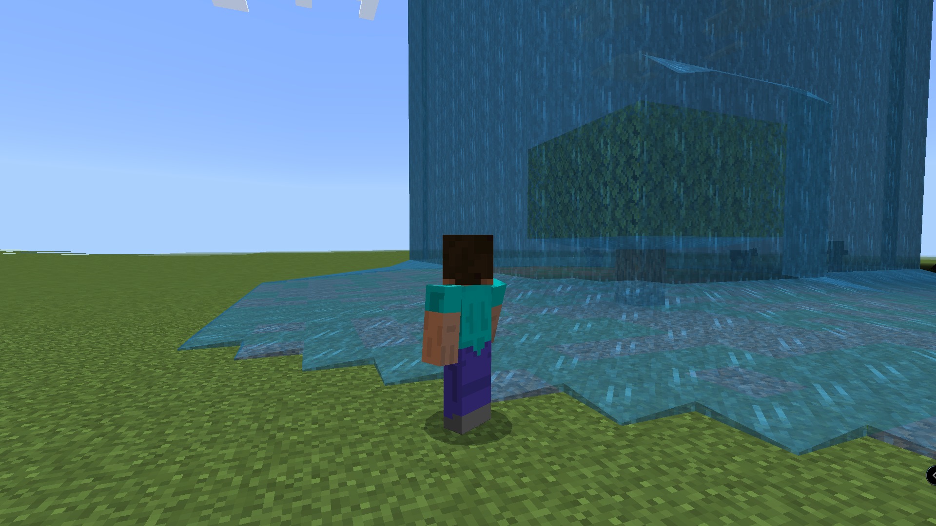 Minecraft character looking at a large waterfall with a block inside the water