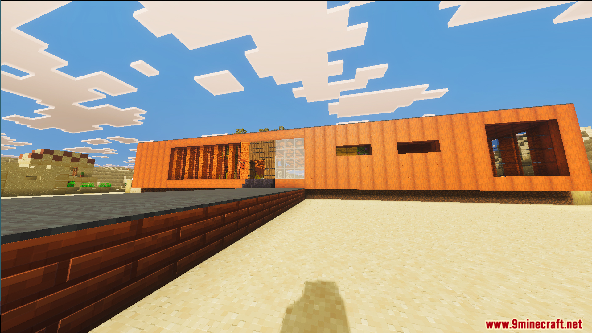 Front view of a long modern orange house located in a desert biome