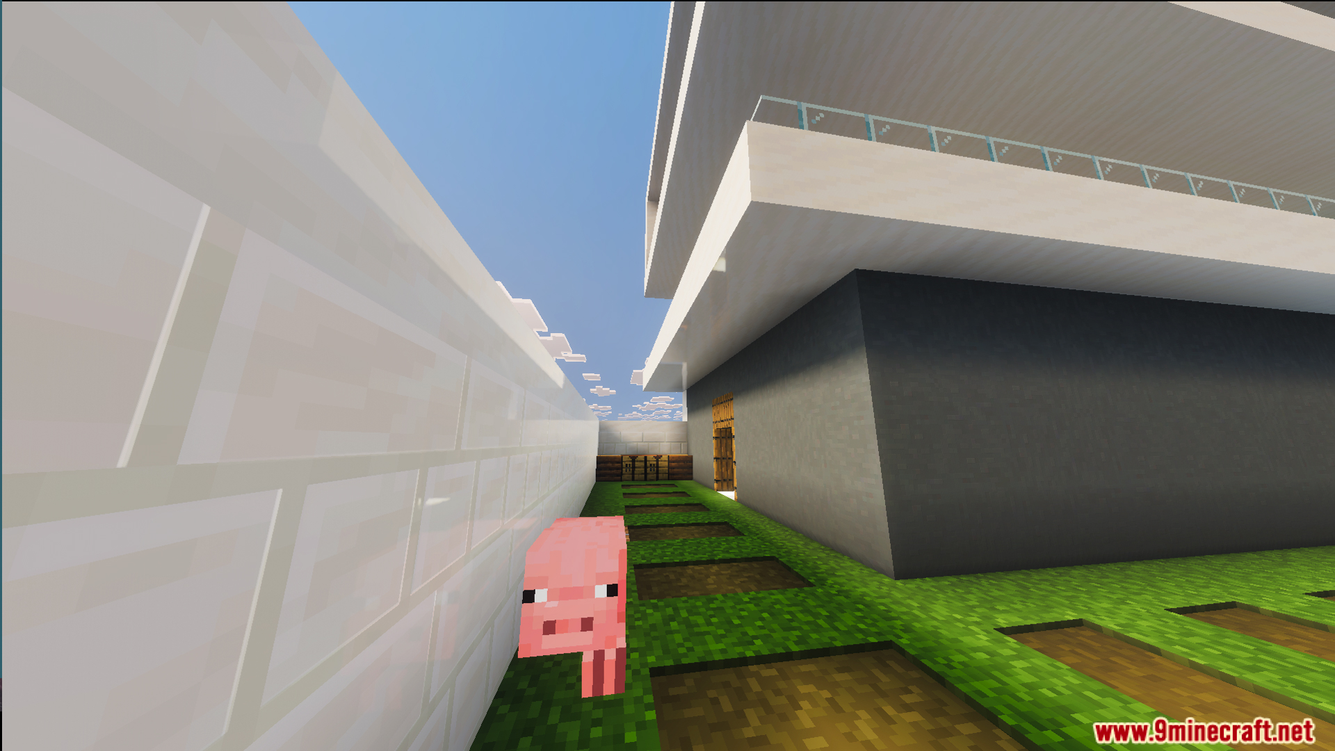 Pink pig standing on a grass path next to a white mansion wall
