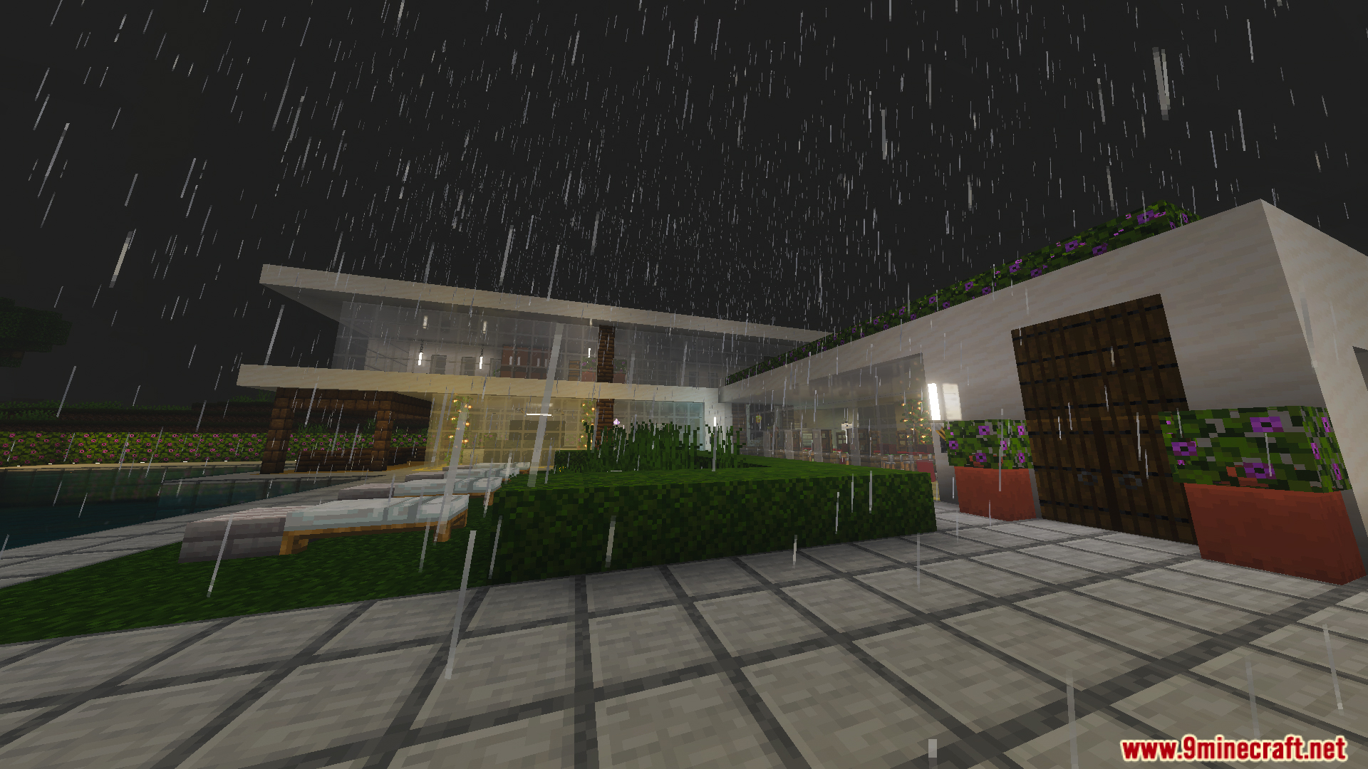 Exterior view of a modern white house with large glass windows during rain