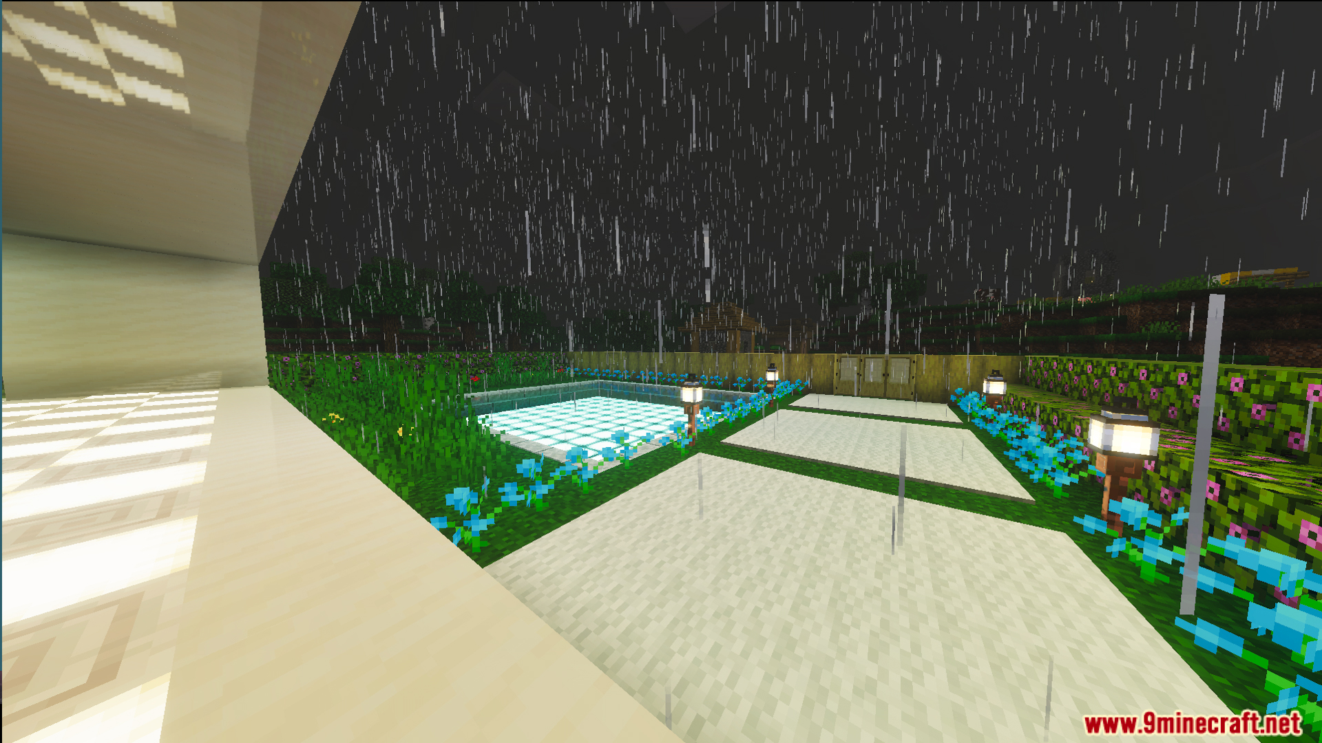 Outdoor patio area with a glowing pool and blue flowers in the rain