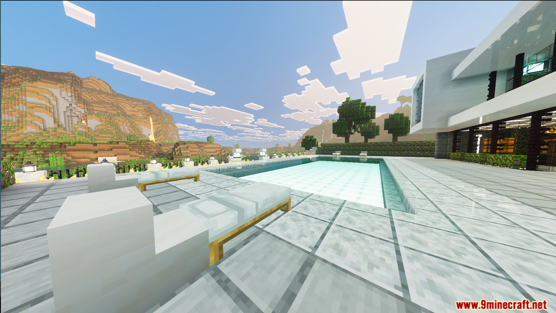 Large swimming pool and white lounge chairs outside the modern white mansion