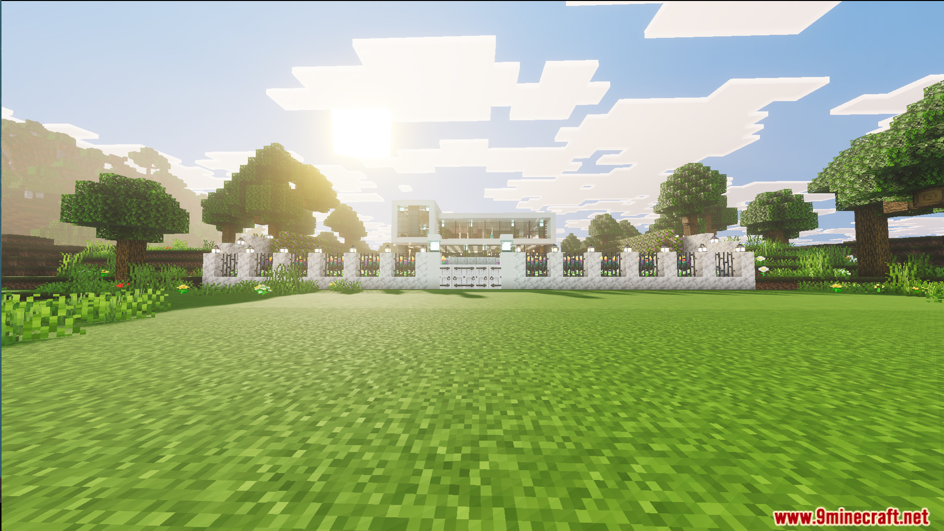 A white fence with lanterns surrounds a large modern house in the plains