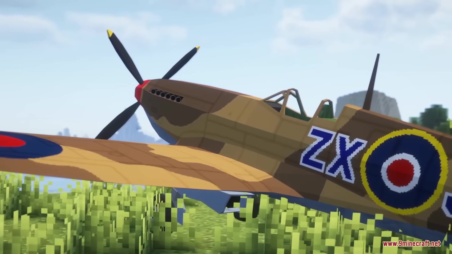 Warfare Wings Mod Screenshot 1 A detailed Supermarine Spitfire fighter plane parked in a grassy Minecraft field